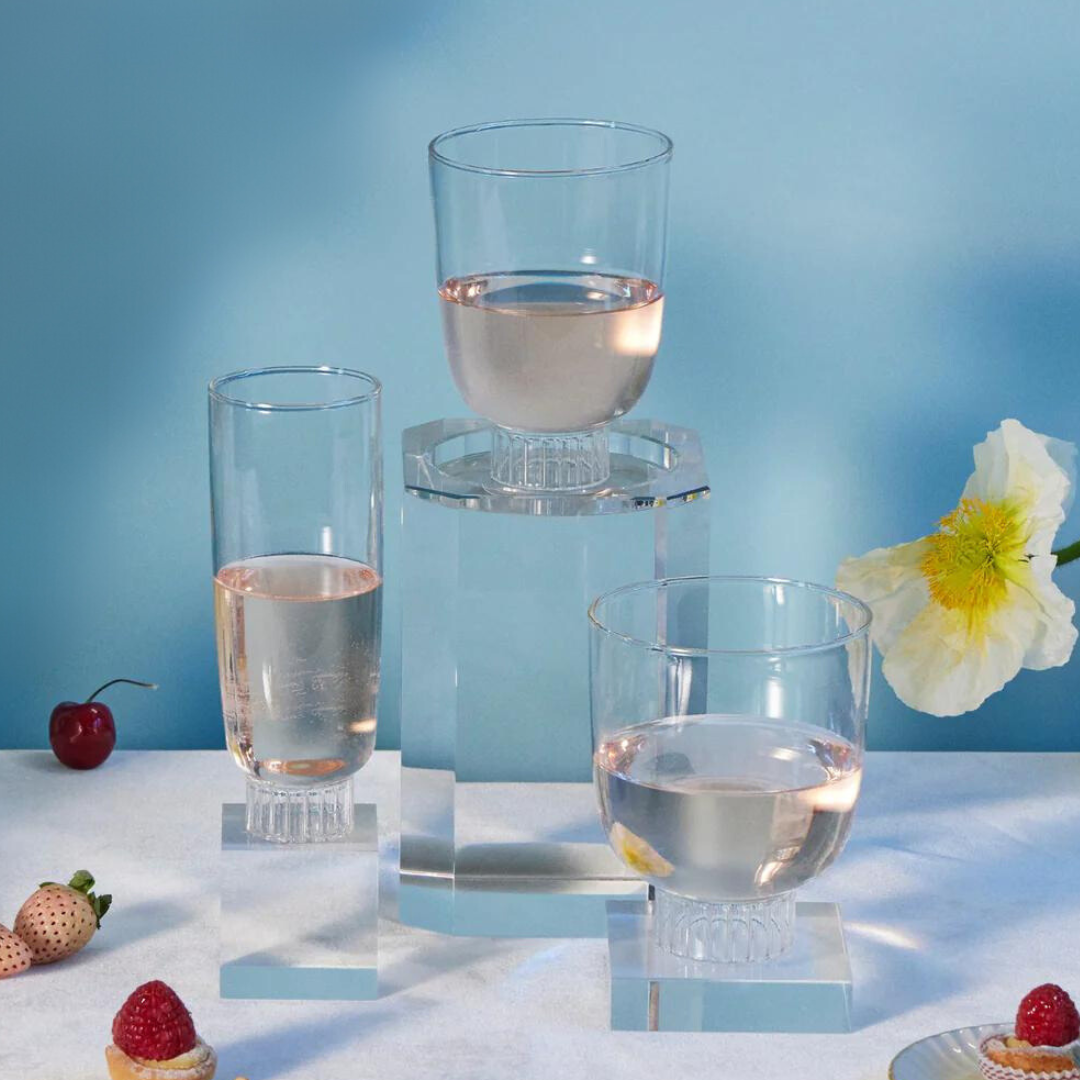 Sprezz clear romantic champagne flute, cocktail glass, and stemless wine glass filled with rose surrounded by flowers, fruits, and dessert. These glasses are lead-free, dishwasher safe and stackable. The fluted bottoms lend a touch of effortless elegance to any party or dinner table. Made of 100% borosilicate which makes them lightweight yet durable and dishwasher safe