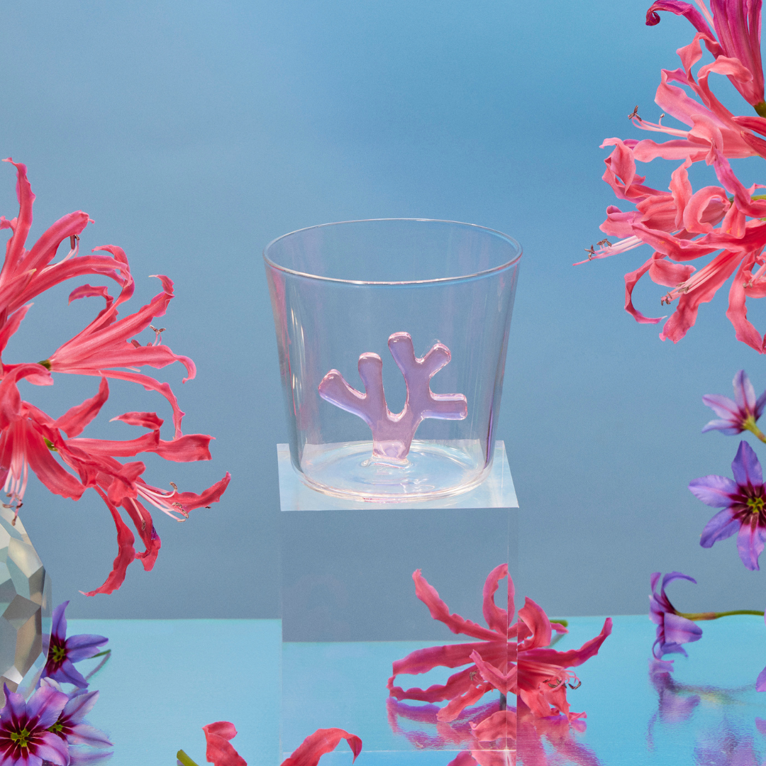 Sprezz tumbler glasses made from durable, non-toxic borosilicate glass that is dishwasher safe on a mirrored table with lots of flowers